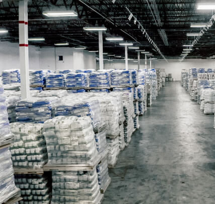 The interior of a warehouse with products shrink-wrapped on palettes.