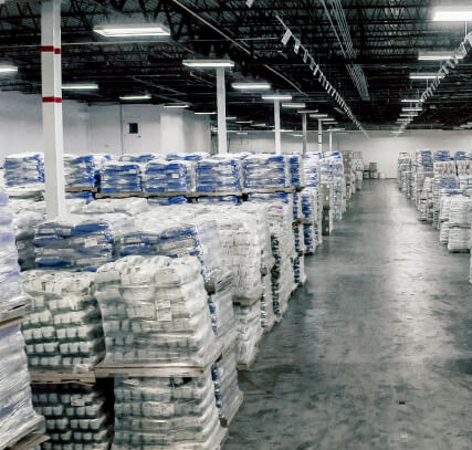 The interior of a warehouse with products shrink-wrapped on pallets.